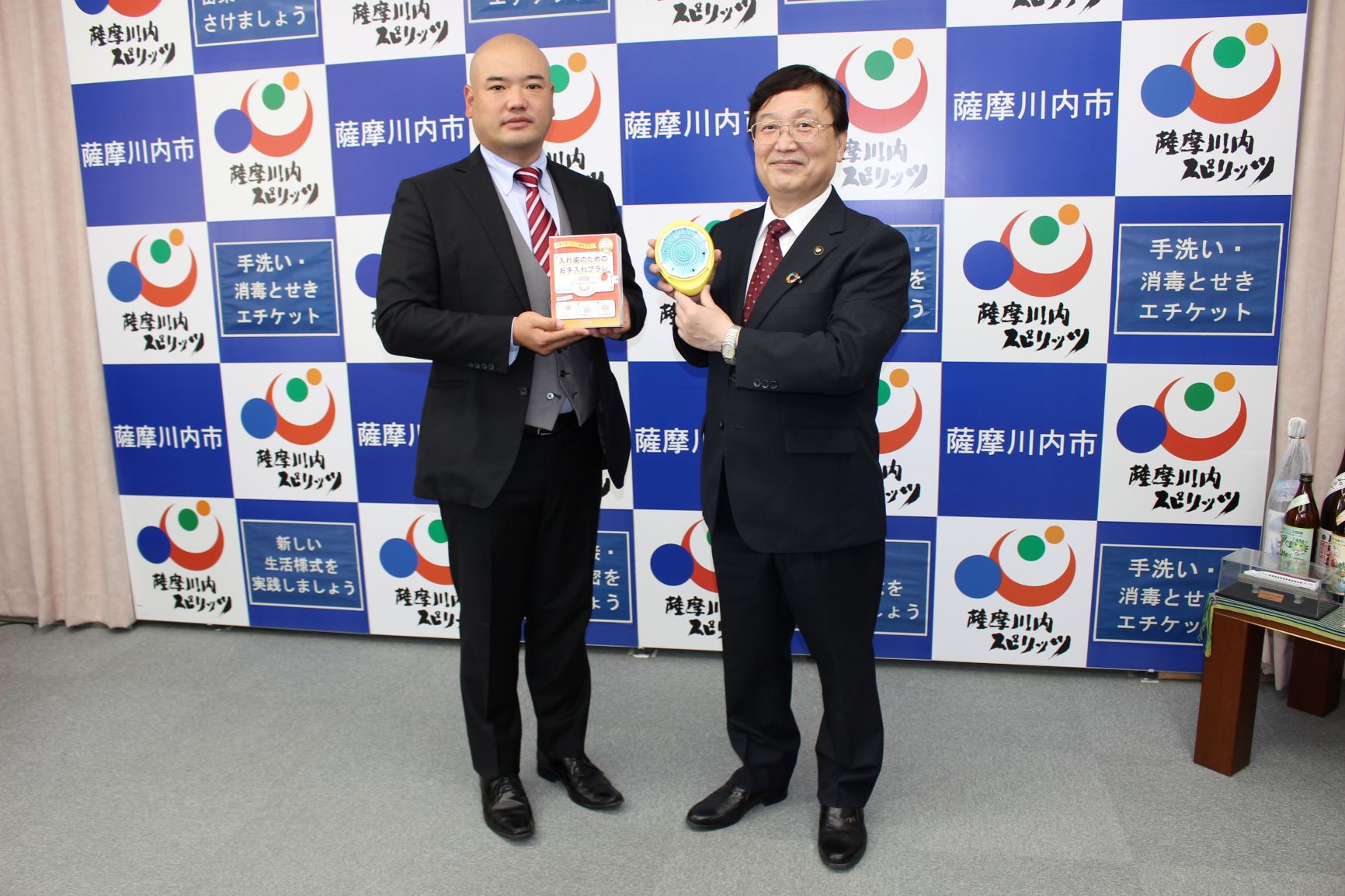 入れ歯専用ブラシの贈呈式で並んで写真に写っている関係者と市長の写真