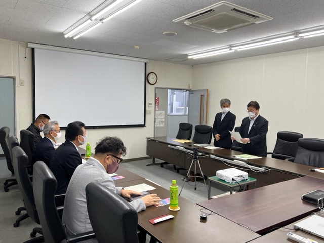 市の企業連携協議会の関係者に向かって原稿を読み上げている市長と関係者の写真