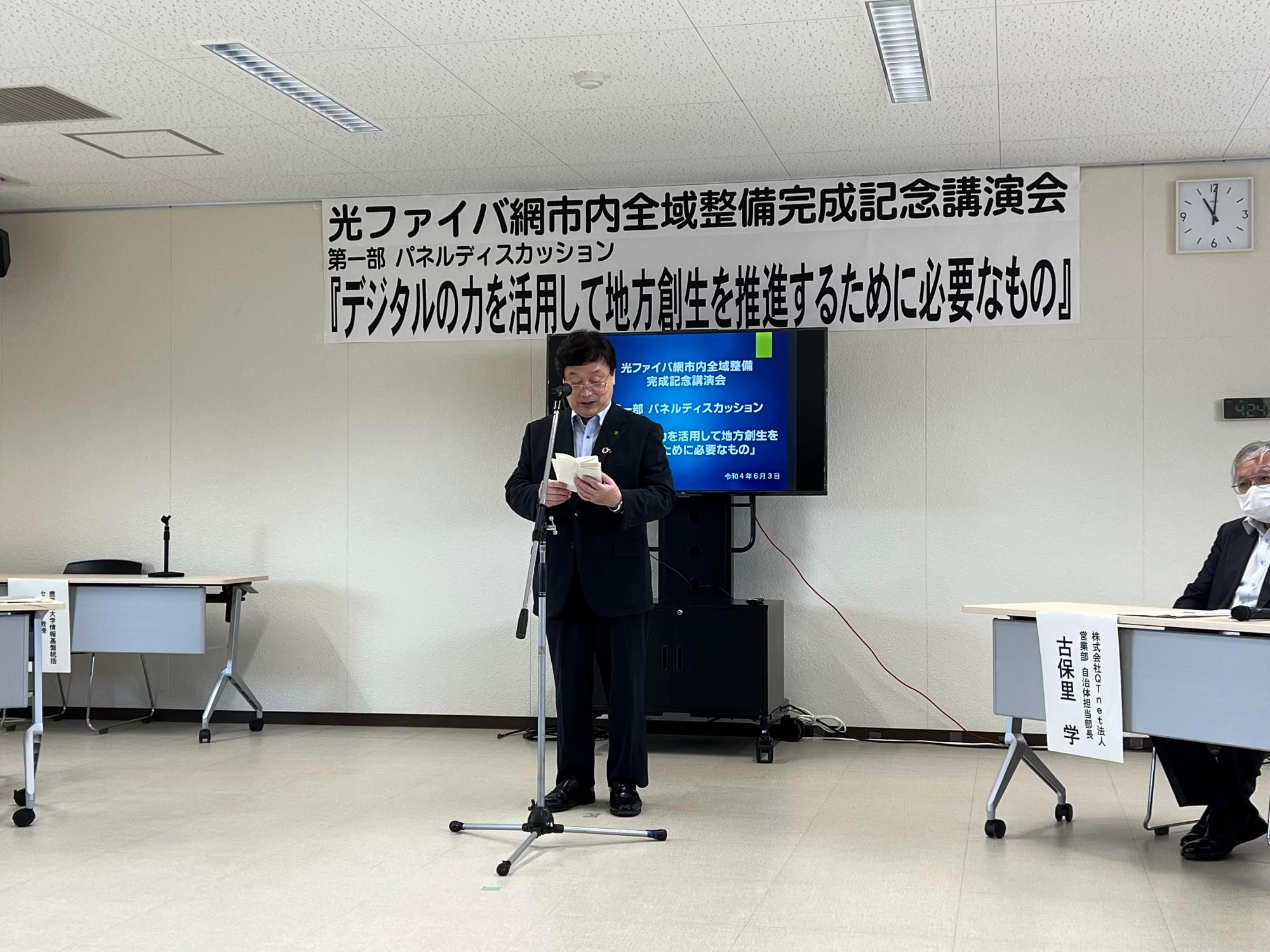 大型テレビの前で原稿を読み上げている市長の写真