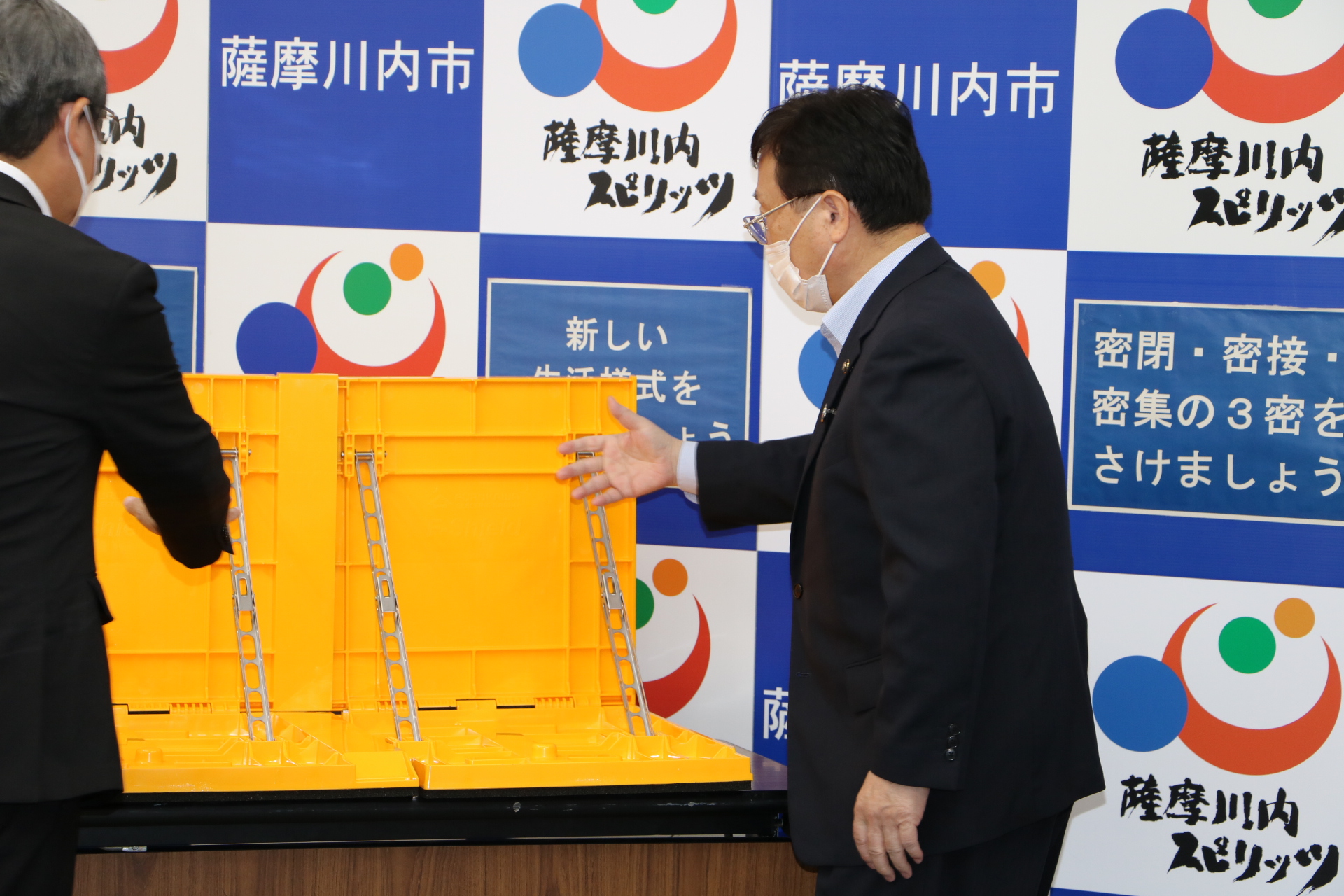 止水板を手で示しながら話すスーツ姿の男性たちの写真
