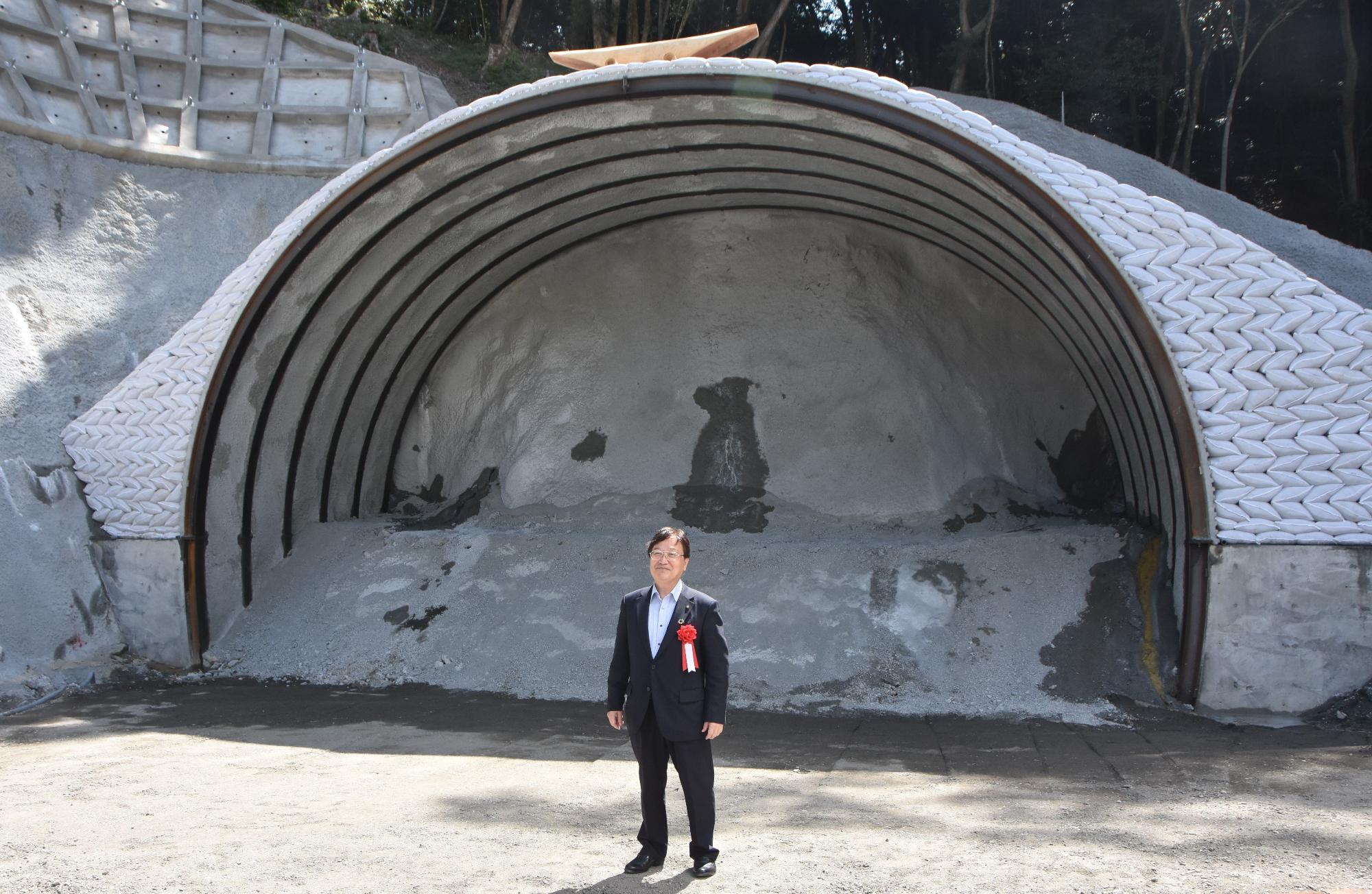 建設途中のトンネルの前に立つ田中市長の写真