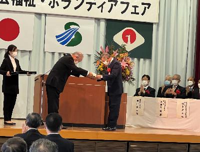 表彰を受ける団体の代表を見守る田中市長の写真