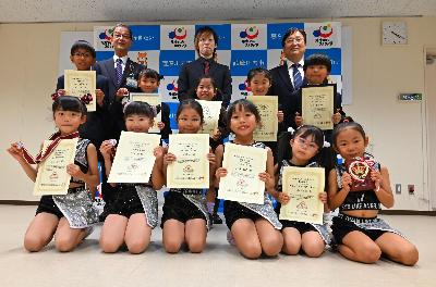 並んで写真に写るダンススタジオ奏のみなさんと田中市長、藤田教育長の写真