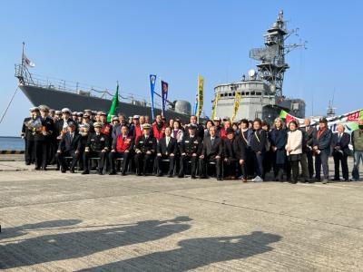護衛艦「せんだい」を背に乗組員や歓迎式に参加した市民らと写真に写る田中市長の写真