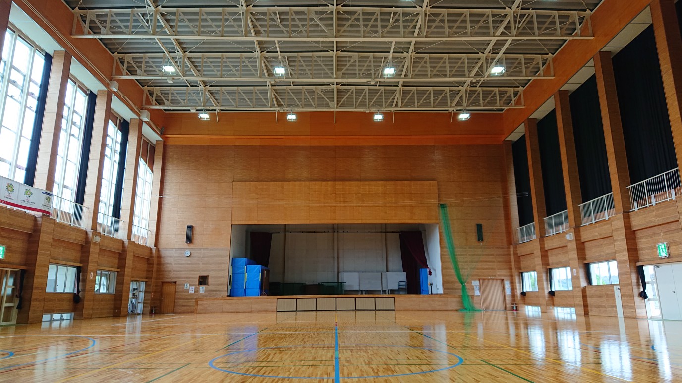 窓から光が入っている誰もいない綺麗な体育館の写真