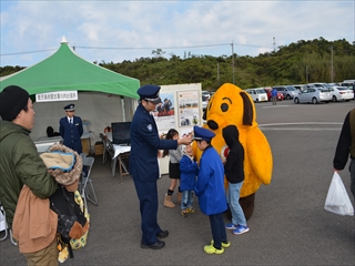 お祭り会場の黄色い犬の着ぐるみと子供たちの写真