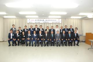 スーツ姿の男性たち20人前後が2列に並んでいる写真