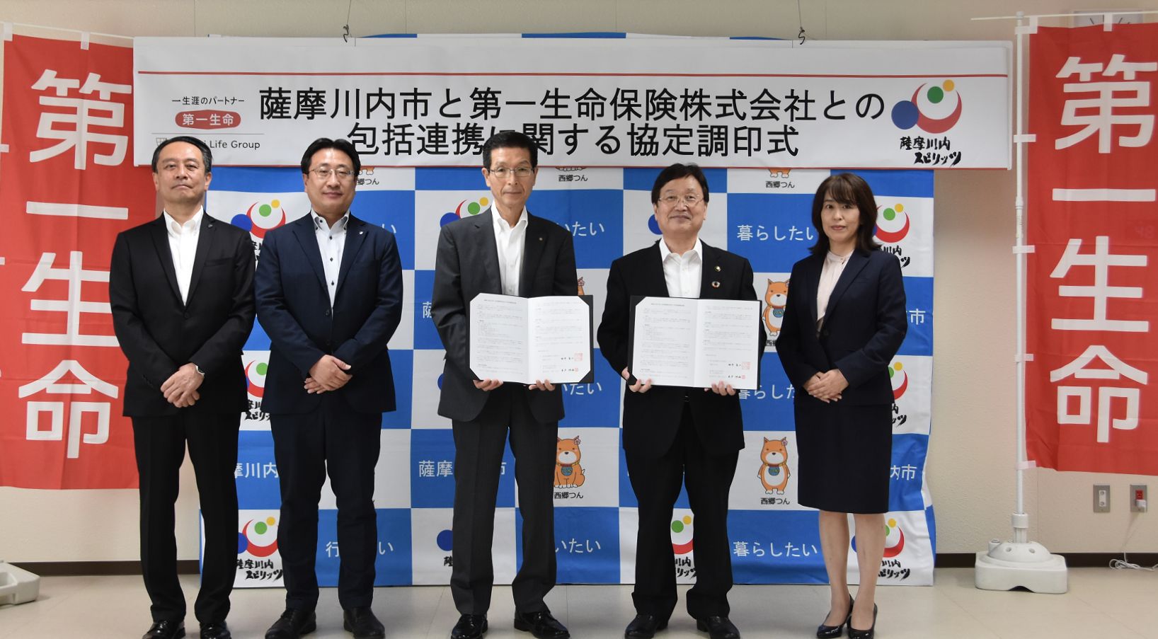 調印された書類を見せる男性たちの写真