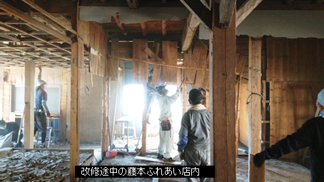 男性たちが木造の家の中を解体して下に瓦礫が積み上げられている、改装途中の藤本ふれあい店内の写真