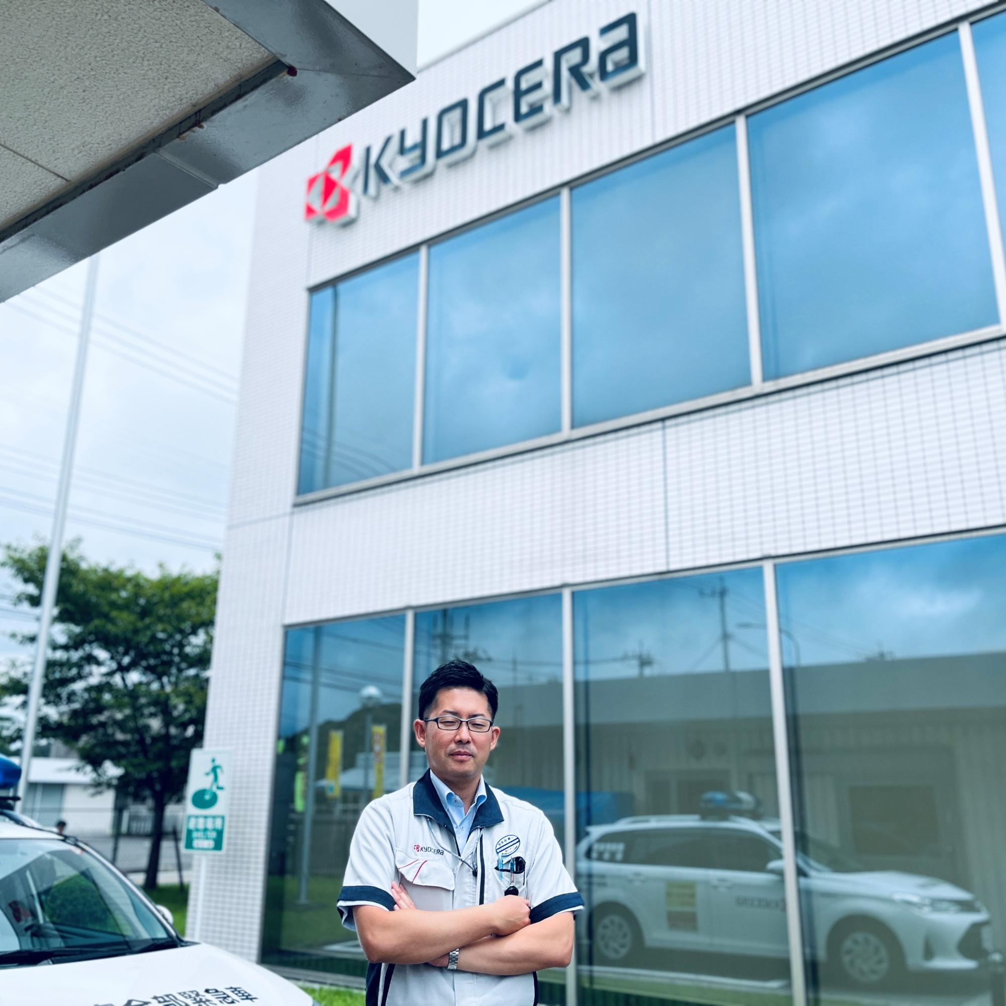 工場の前で腕を組んで立つ京セラ川内工場の社員