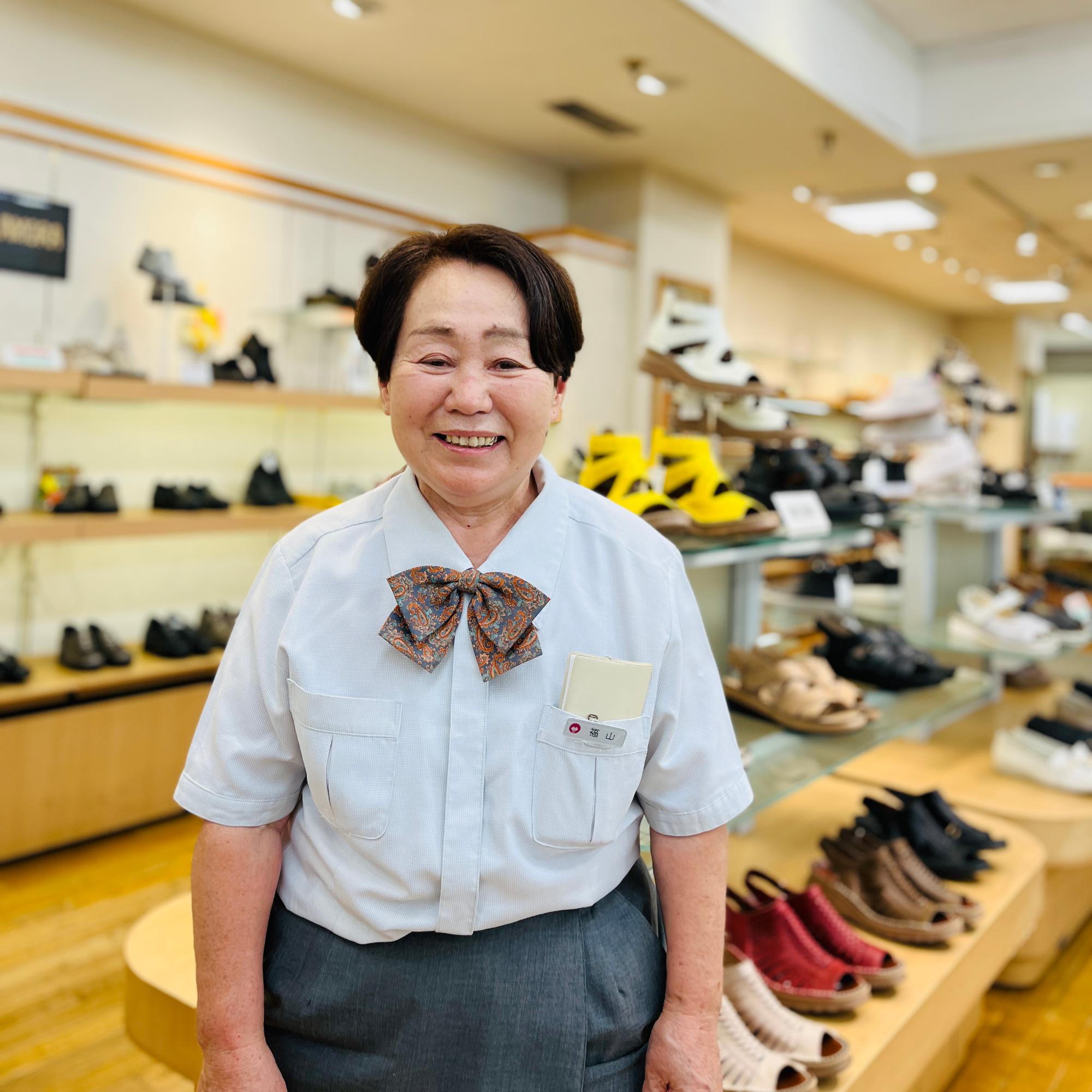 売り場の前で笑顔を見せる福山さん