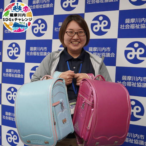 寄贈されたランドセルと笑顔の井上さん