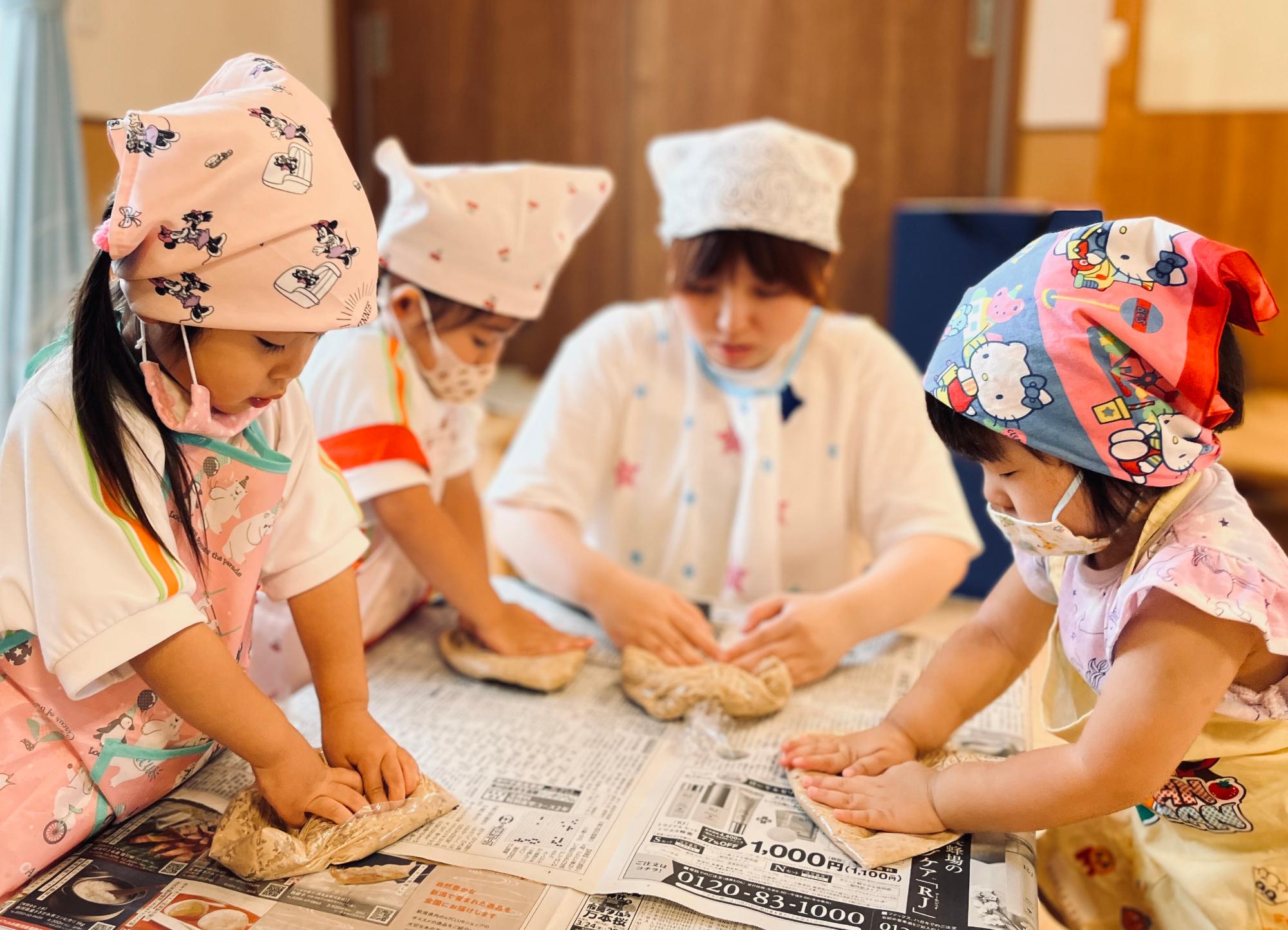 大豆を潰す先生と園児