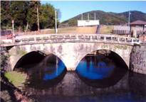 川の水に反射して二つの円が並んでいるように見える眼鏡橋の写真