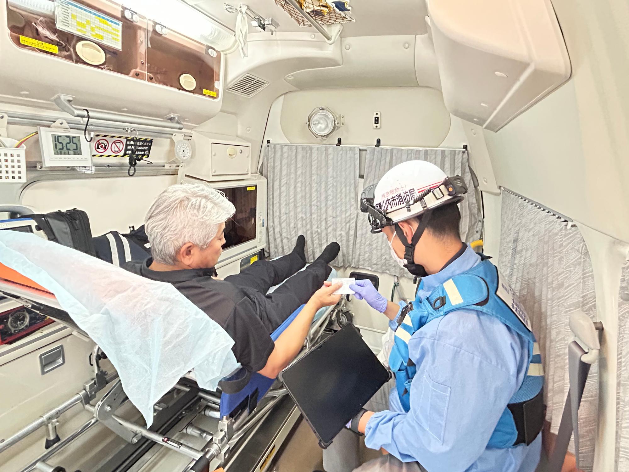傷病者からマイナンバーカードを使用する救急車内での様子