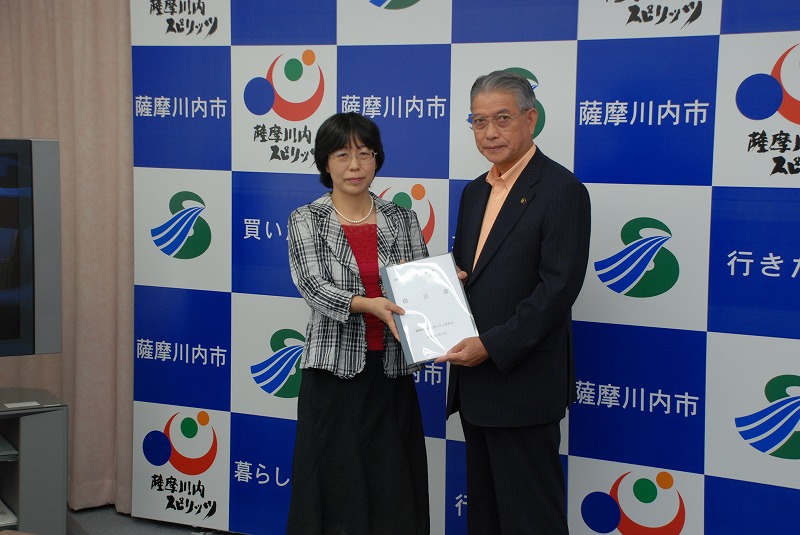 第3期薩摩川内市女性50人委員会の女性が、薩摩川内市長に提言書を渡している画像