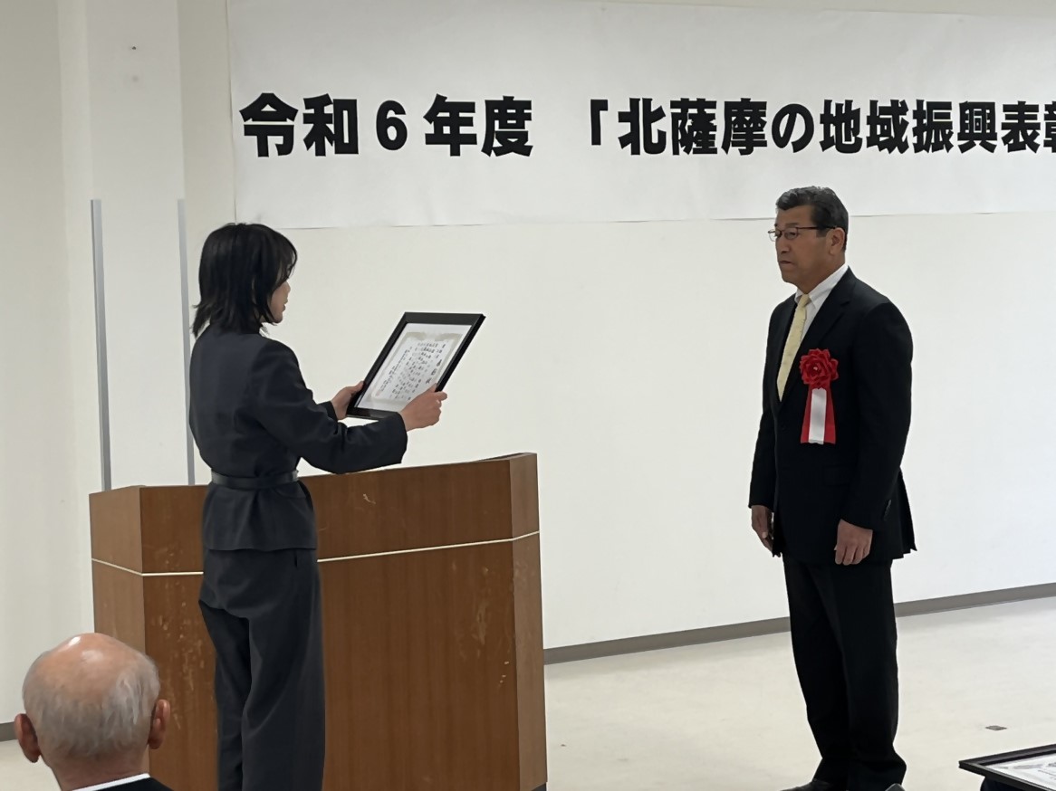 令和6年度「北薩摩の地域振興表彰」表彰式で奨励賞の賞状を受け取る里地区コミュニティ協議会長を写した写真