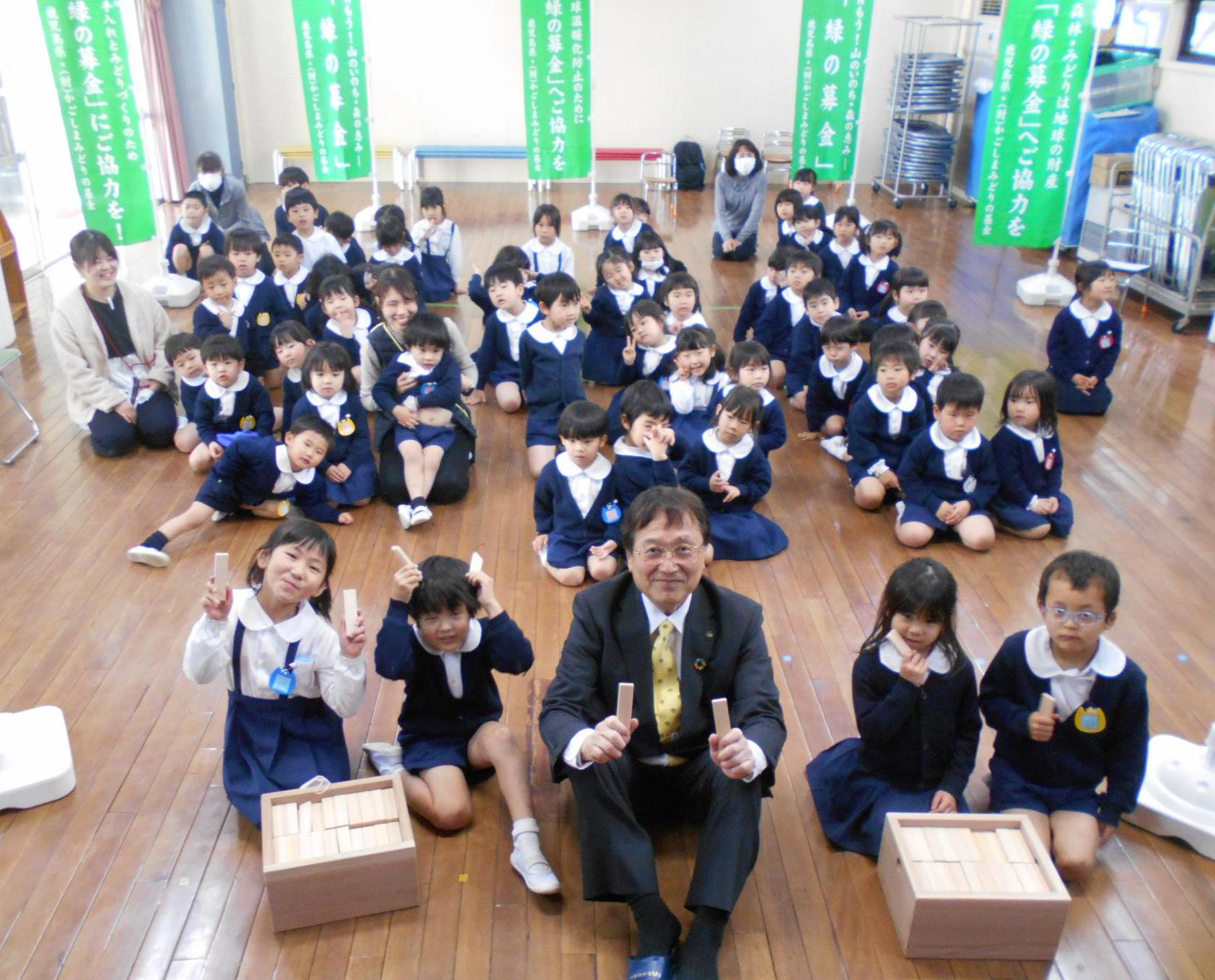 積み木を持って園児たちと記念写真