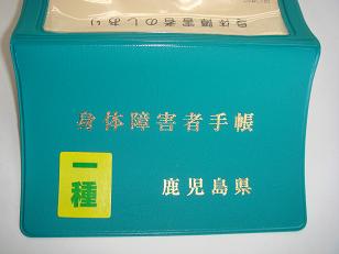 「一種」と書かれたステッカーが貼られた緑色の身体障害者手帳の写真