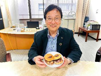 ジビエプルドボアバーガーを手にする田中市長の写真