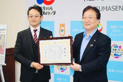 感謝状を手に写真に写る田ノ上社長と田中市長