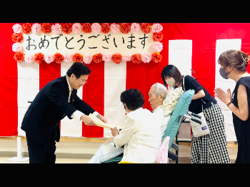 田中市長が寺𦚰氏へ勲記を手渡すようす