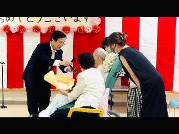 田中市長が寺𦚰氏へ勲章を手渡すようす