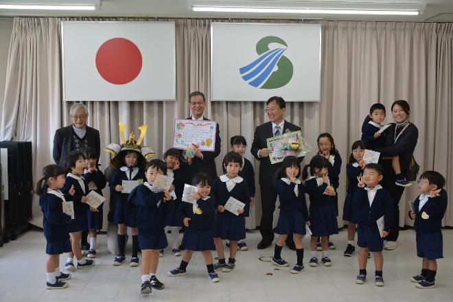 聖母幼稚園の園児の皆さんと田中市長、藤田教育長の集合写真