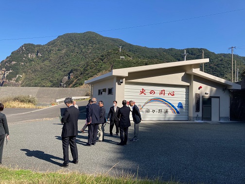 火の用心、瀬々野浦、と書かれたシャッターの防災センターを視察している市長と関係者たちの写真
