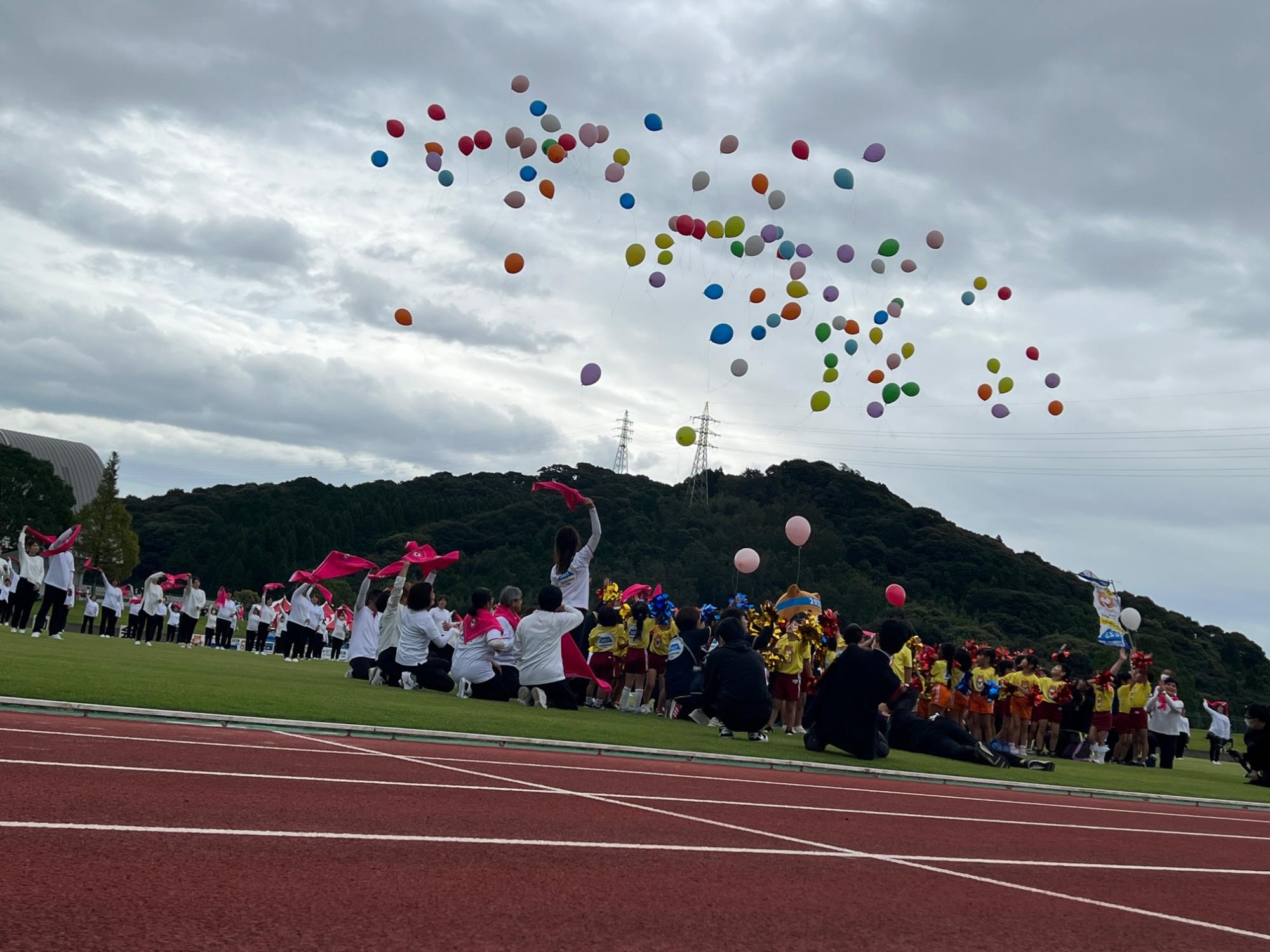 競技場から沢山の風船が飛んでいる写真