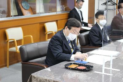 協定書に押印する田中市長の写真