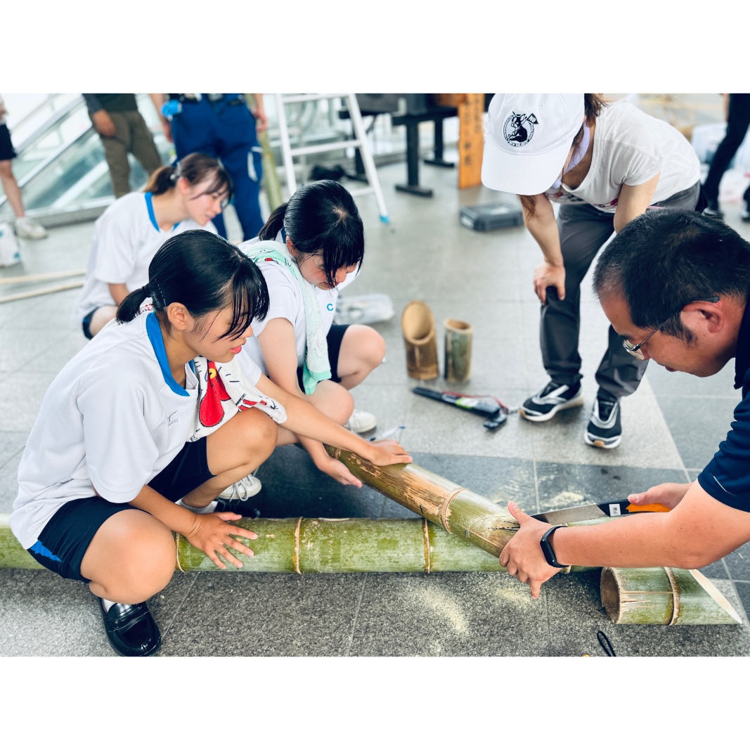 竹のオブジェを設営する川内商工高等学校の生徒と大人たち