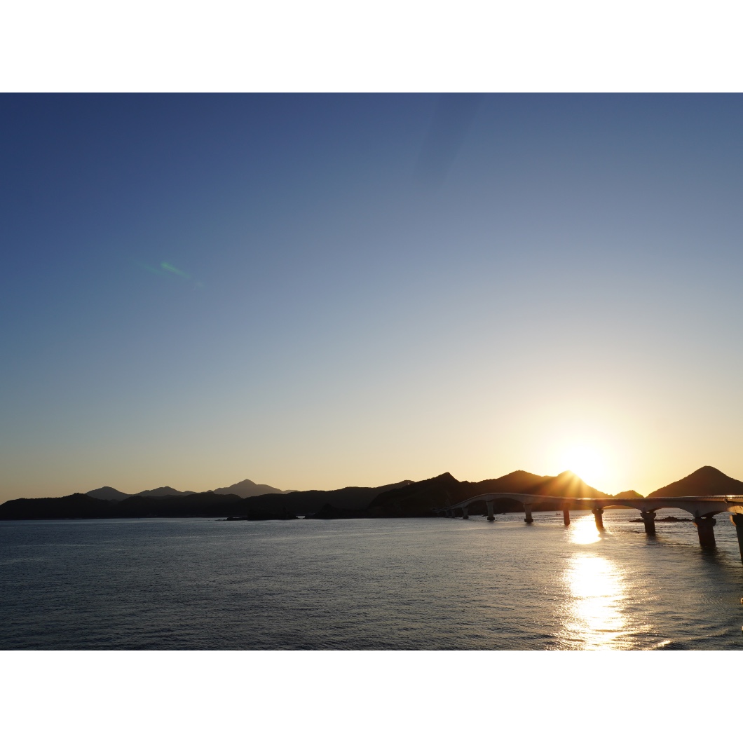 夕日に照らされる甑島の海と甑大橋
