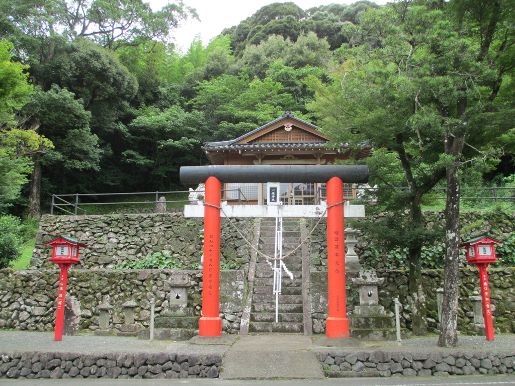 木に囲まれた神社の鳥居が見える入口の写真