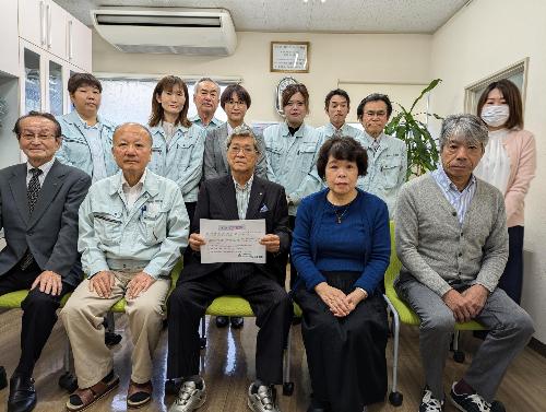 宣言文を手に持って正面に向けている株式会社 アシスト設計の代表取締役　今村さまと従業員のみなさま