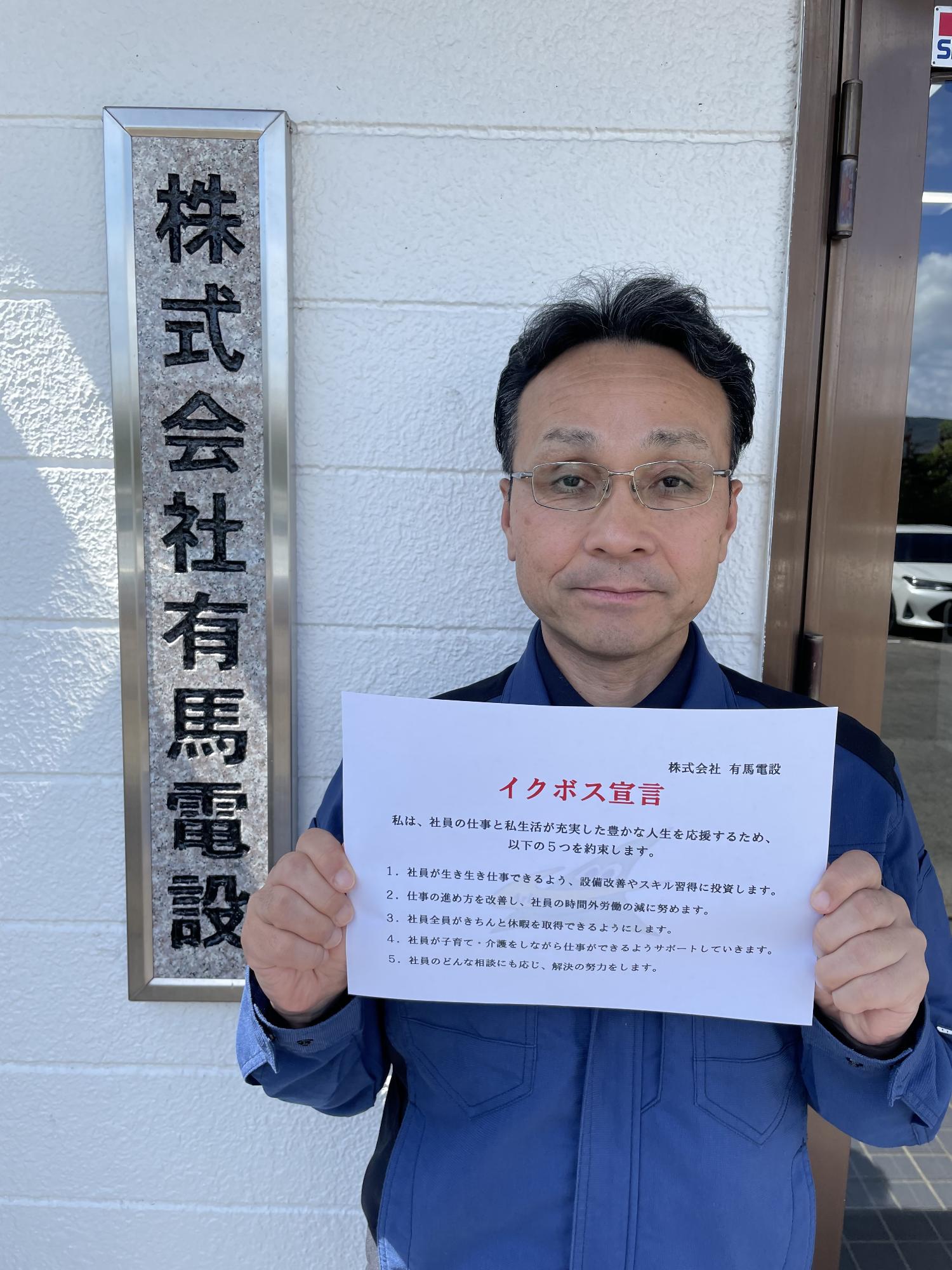 有馬電設の島村社長が宣言文を持っているところ