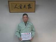 宣言文を手に持って正面に向けている丸澄建設株式会社の代表取締役 有村 義郎の写真