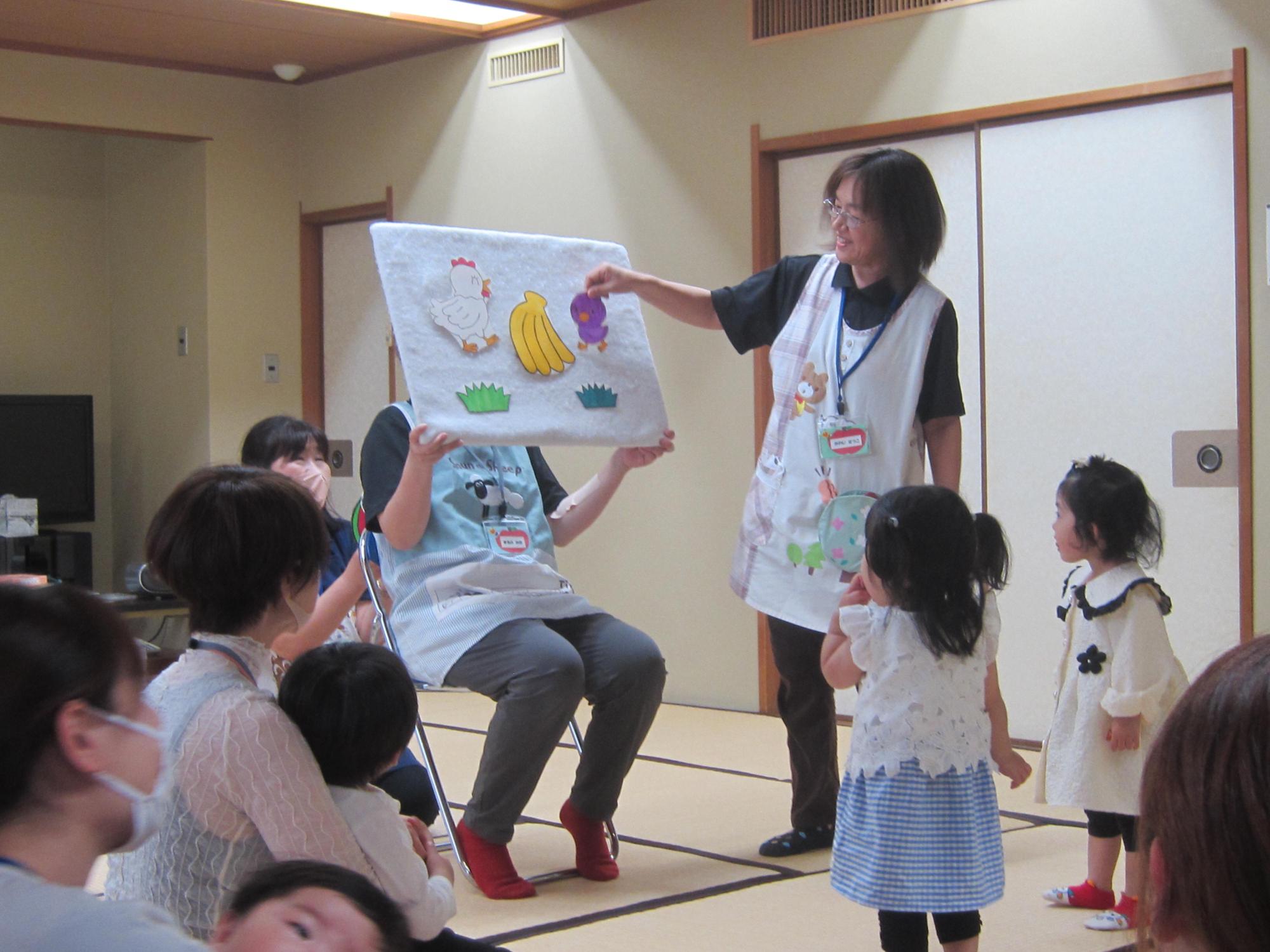 親子で絵本の読み聞かせを聞いている画像
