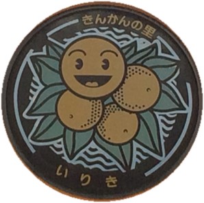金柑の実に笑顔が描かれている入来（きんかんちゃん）のマンホール蓋の写真